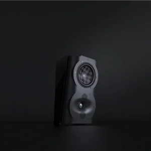 A speaker is sitting in the dark on top of a table.