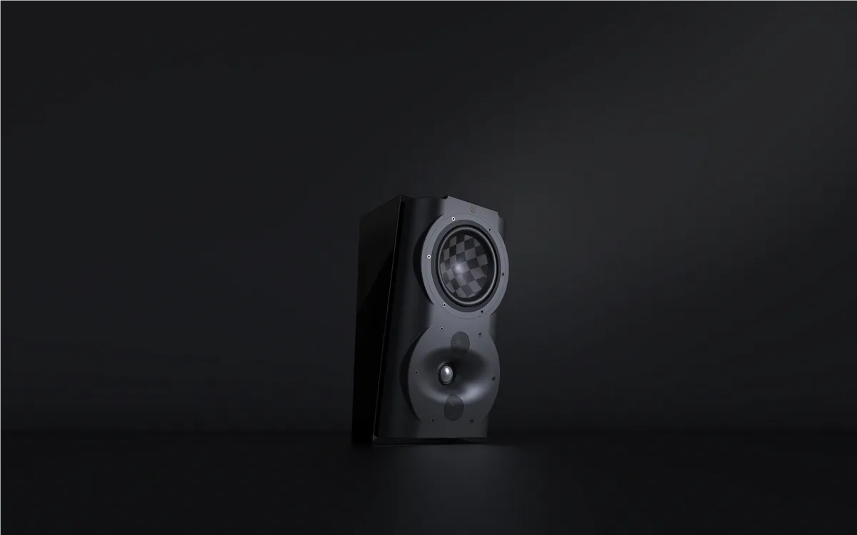 A speaker is sitting in the dark on top of a table.